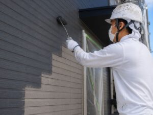 グレーの塗料で中塗り作業をしている塗装職人